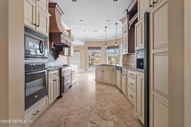 kitchen with a peninsula, cream cabinetry, a sink, backsplash, and black appliances