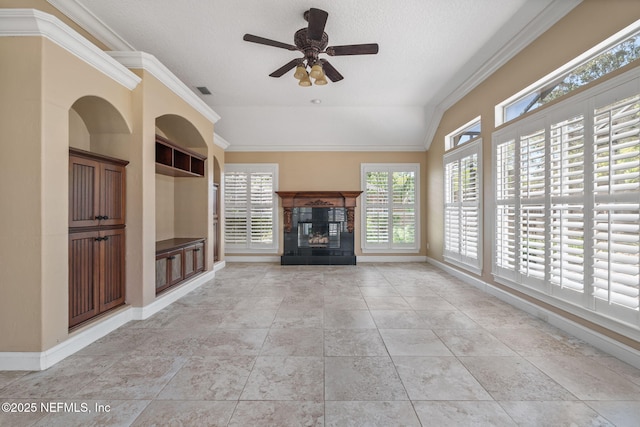 unfurnished living room featuring ceiling fan, a fireplace, baseboards, light tile patterned floors, and ornamental molding