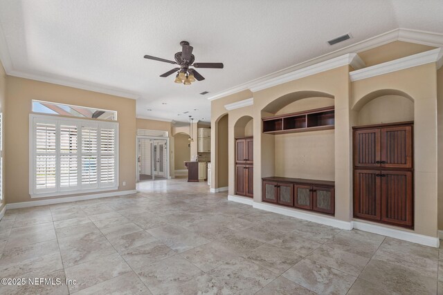 unfurnished living room featuring crown molding, a ceiling fan, baseboards, and visible vents
