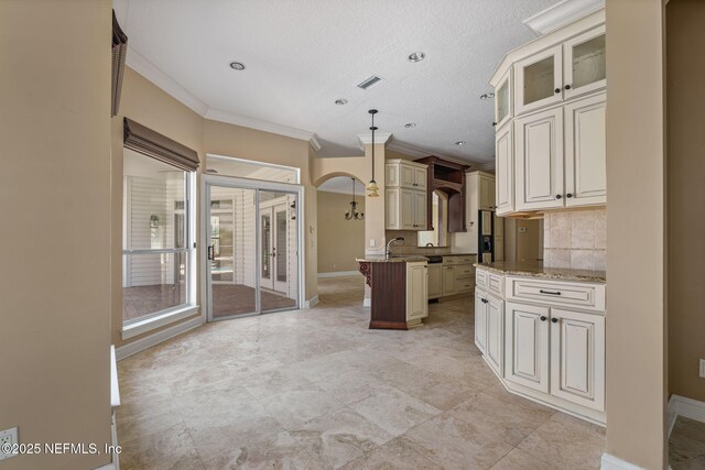 kitchen with crown molding, light stone counters, a peninsula, baseboards, and glass insert cabinets
