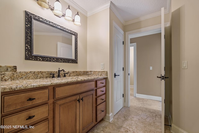bathroom with vanity, a textured ceiling, baseboards, and crown molding