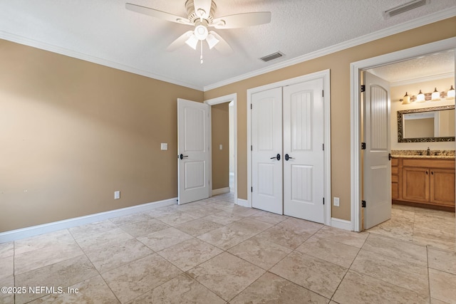unfurnished bedroom with crown molding, baseboards, visible vents, and a closet