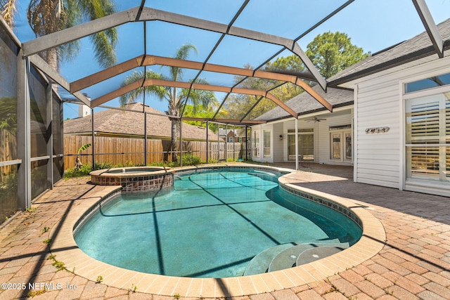 view of swimming pool with ceiling fan, a lanai, a pool with connected hot tub, a fenced backyard, and a patio