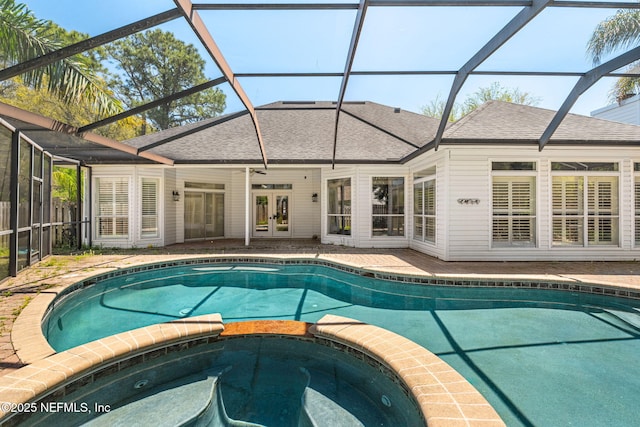 view of swimming pool featuring a lanai, a patio area, a pool with connected hot tub, and french doors