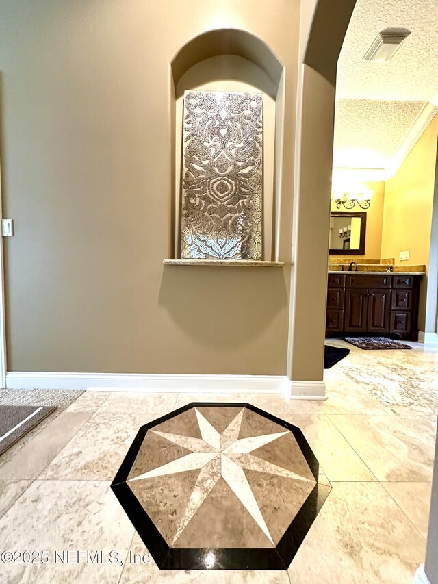hallway with a textured ceiling and baseboards