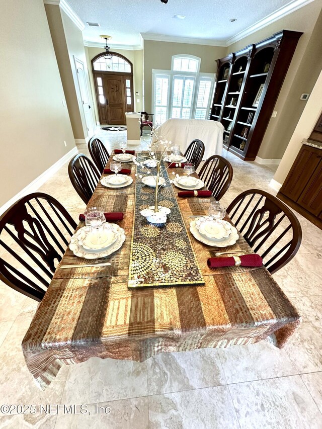 dining room featuring baseboards, ornamental molding, and a textured ceiling