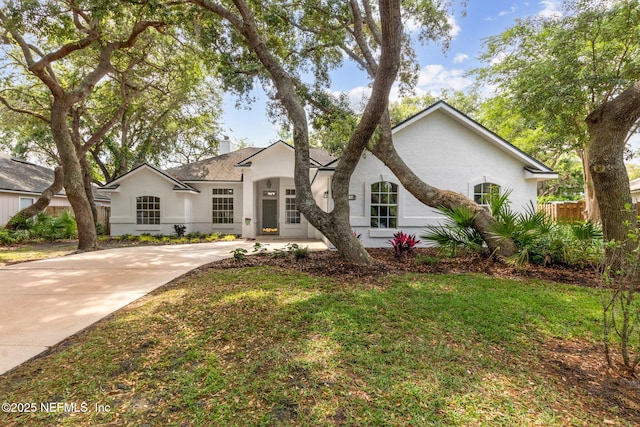 single story home featuring fence, stucco siding, a chimney, and driveway