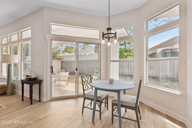 sunroom featuring a healthy amount of sunlight and a chandelier