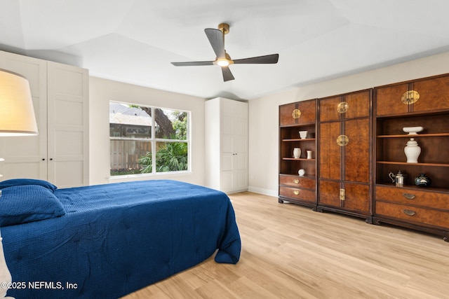 bedroom featuring light wood-style floors, baseboards, and ceiling fan