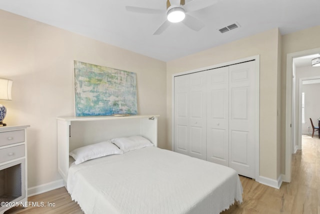 bedroom featuring light wood-style floors, a ceiling fan, baseboards, visible vents, and a closet