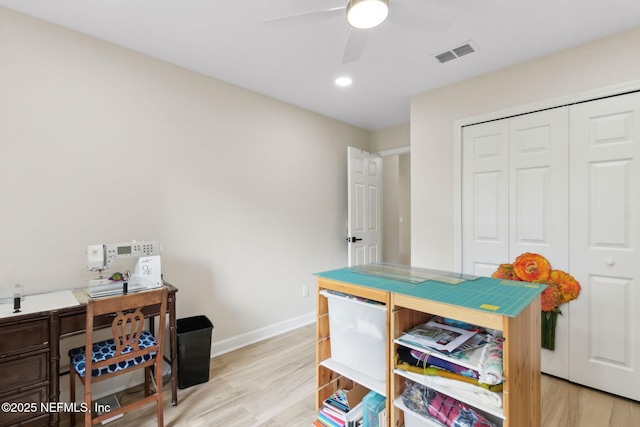 home office featuring light wood-type flooring, a ceiling fan, baseboards, and visible vents