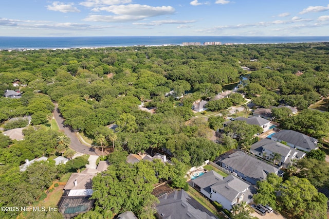 drone / aerial view with a water view, a residential view, and a wooded view