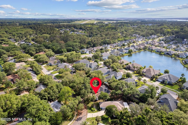 aerial view featuring a water view, a view of trees, and a residential view