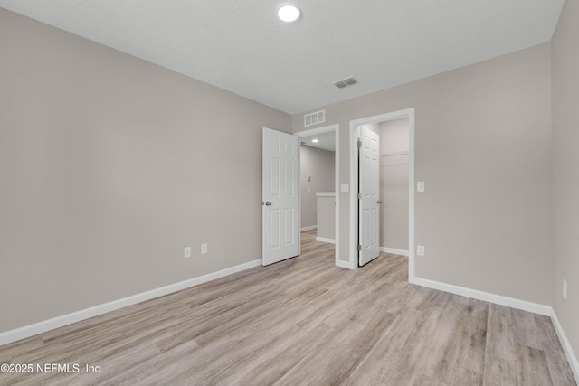unfurnished bedroom with visible vents, recessed lighting, light wood finished floors, and baseboards
