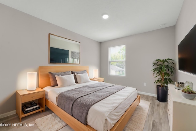 bedroom with baseboards and light wood finished floors