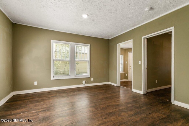 unfurnished room with a textured ceiling, crown molding, and dark wood finished floors