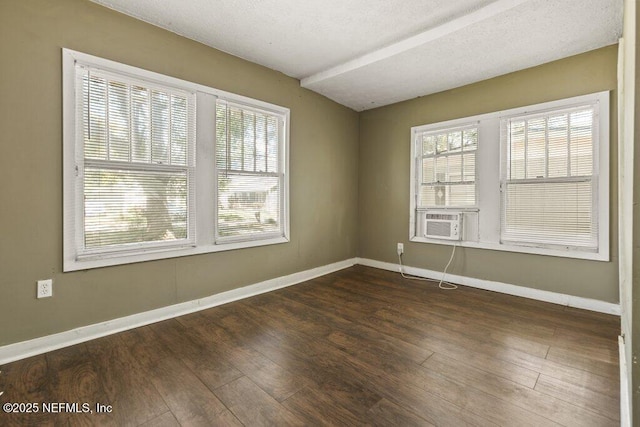 empty room with baseboards, wood finished floors, and plenty of natural light