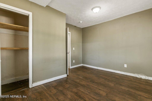 unfurnished bedroom with dark wood-style flooring, a closet, a textured ceiling, and baseboards