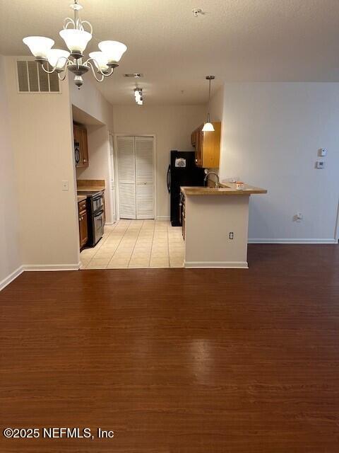 6860 Skaff Ave Unit 2-6, Jacksonville, FL 32244 - kitchen with black appliances, visible vents, a chandelier, and baseboards