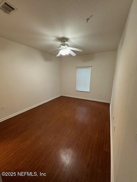 6860 Skaff Ave Unit 2-6, Jacksonville, FL 32244 - empty room featuring visible vents, ceiling fan, dark wood-style floors, and baseboards