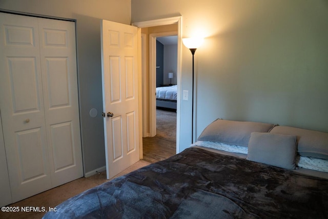 bedroom with baseboards, carpet, and a closet