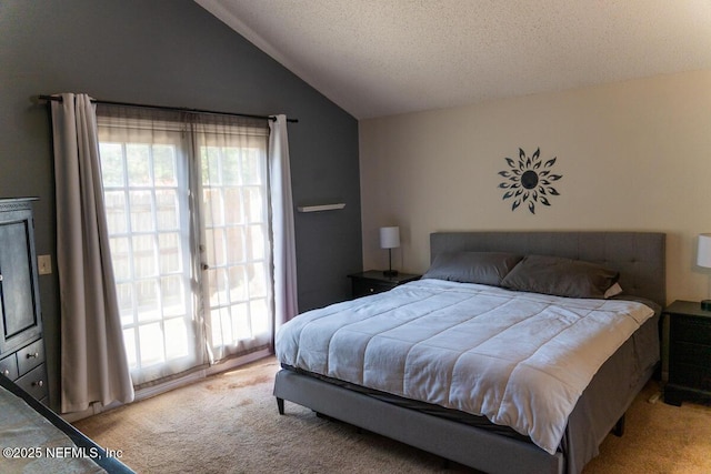 bedroom with a textured ceiling, lofted ceiling, and carpet