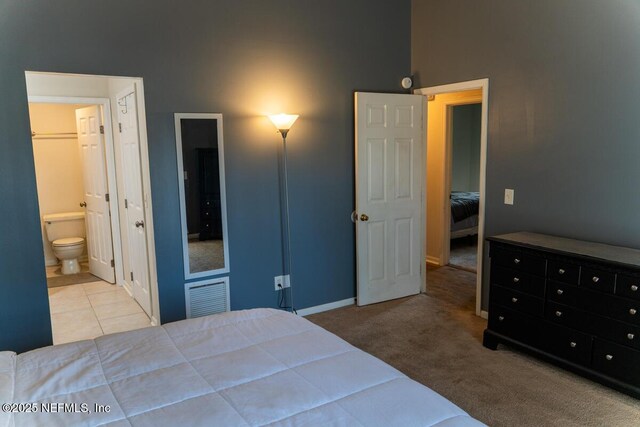 bedroom with baseboards, carpet flooring, ensuite bath, and visible vents