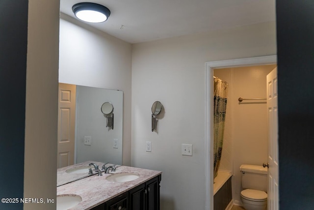 bathroom with double vanity, a sink, and toilet