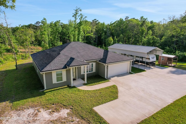 ranch-style home with a forest view, driveway, roof with shingles, and a front lawn