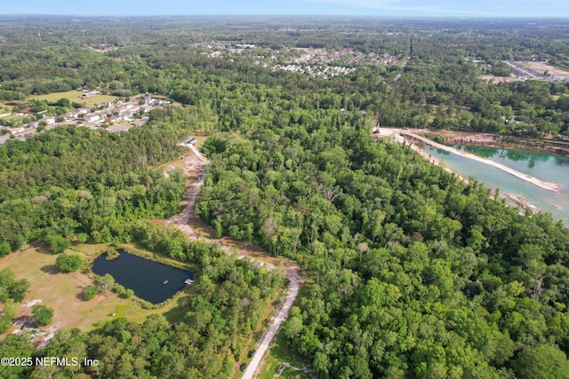 drone / aerial view featuring a water view and a wooded view