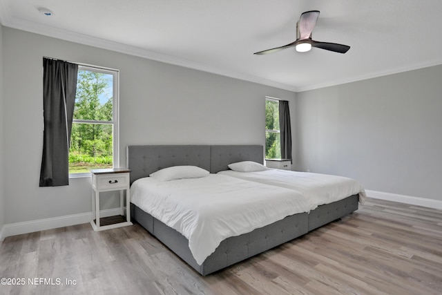 bedroom featuring a ceiling fan, baseboards, ornamental molding, and wood finished floors