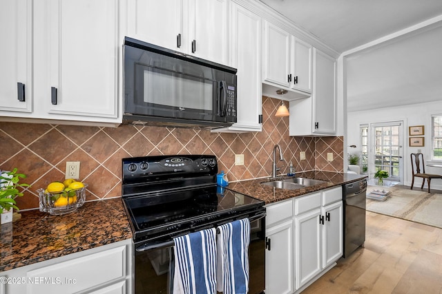 830 Cedar St Unit 830, Jacksonville, FL 32207 - kitchen featuring a sink, light wood-style floors, dark stone countertops, white cabinetry, and black appliances