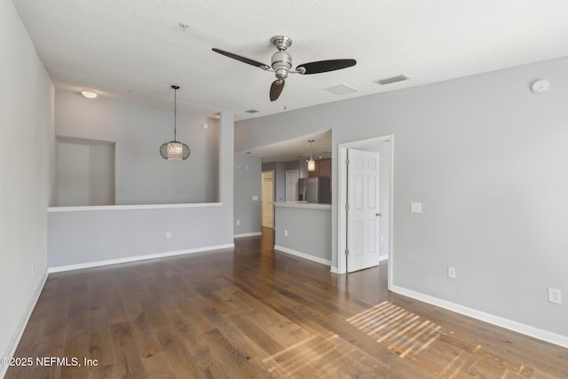 empty room with ceiling fan, wood finished floors, baseboards, and a smoke detector