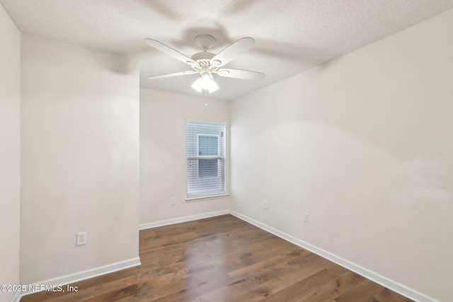 empty room with ceiling fan, wood finished floors, baseboards, and a textured ceiling