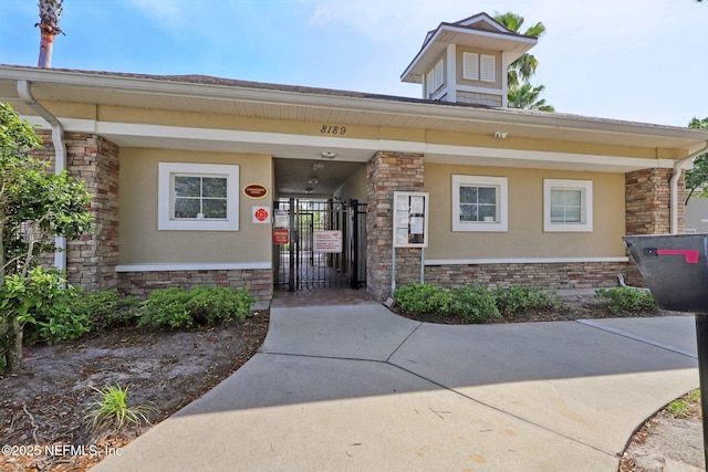 view of front of home featuring a gate and stucco siding