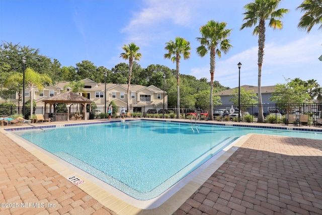 community pool featuring a gazebo, fence, and a patio area