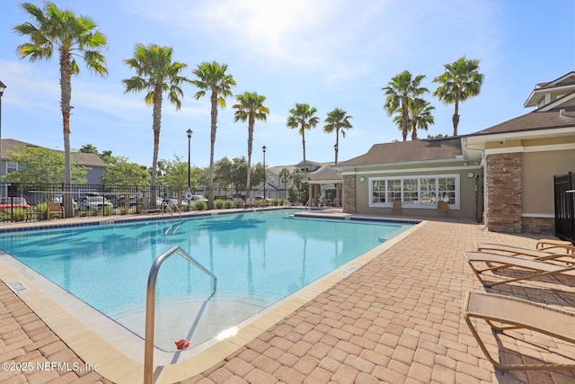 community pool featuring a patio area and fence