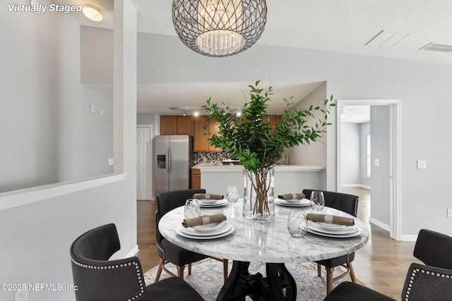 dining area with light wood finished floors and a chandelier