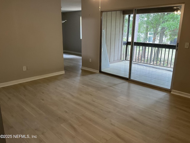 spare room featuring baseboards and wood finished floors