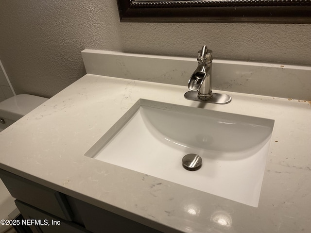 details featuring a textured wall and vanity