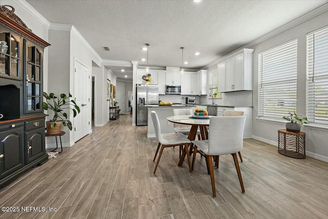 21 Yellow Iris Ct, Ponte Vedra, FL 32081 - dining space with crown molding, light wood-style floors, and visible vents