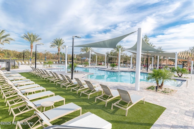 community pool with a lawn, a patio, and fence