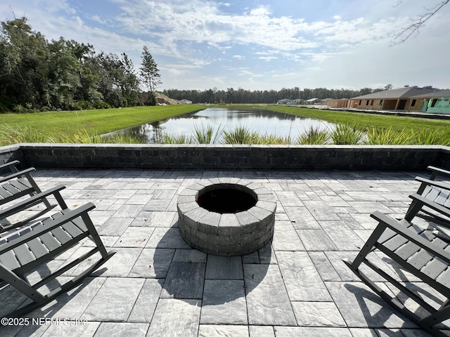 view of patio featuring a water view and a fire pit