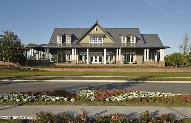 view of front facade with french doors, a front yard, and metal roof