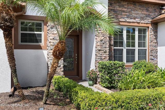 entrance to property with stucco siding and stone siding