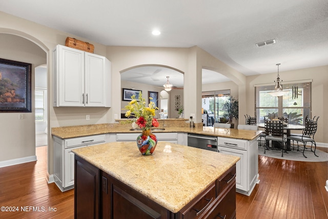 kitchen with visible vents, stainless steel dishwasher, a kitchen island, white cabinets, and dark wood finished floors
