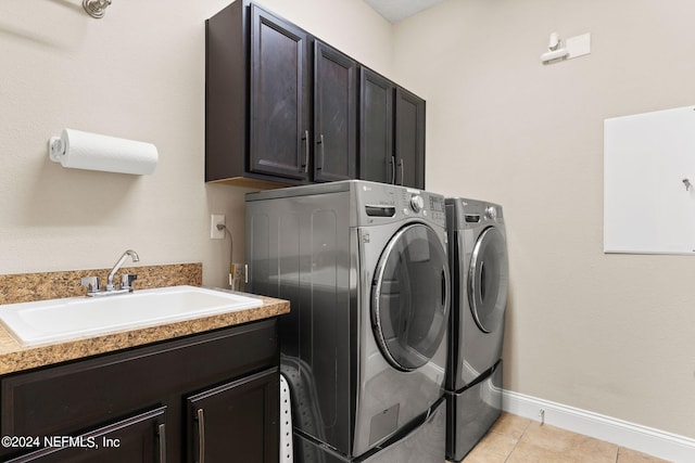 laundry room with cabinet space, baseboards, washer and clothes dryer, and a sink