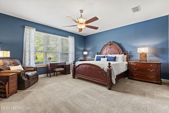 carpeted bedroom with baseboards, ceiling fan, a textured ceiling, and visible vents