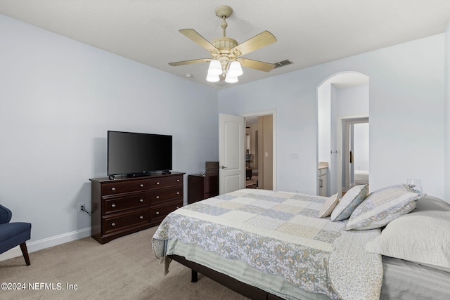 bedroom featuring light colored carpet, arched walkways, a ceiling fan, baseboards, and visible vents
