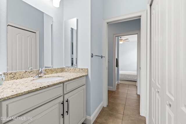 bathroom with baseboards, ceiling fan, tile patterned flooring, and vanity